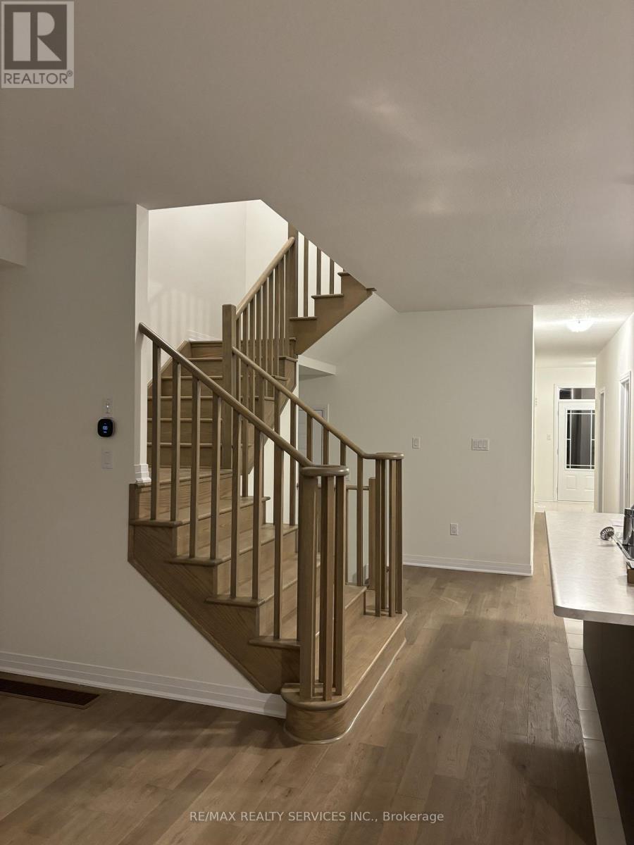 A staircase with a wooden banister and steps leads up to a white wall.
