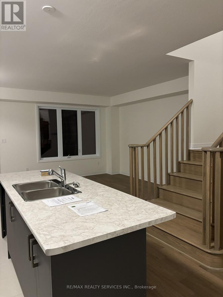 A kitchen with a sink and a staircase.