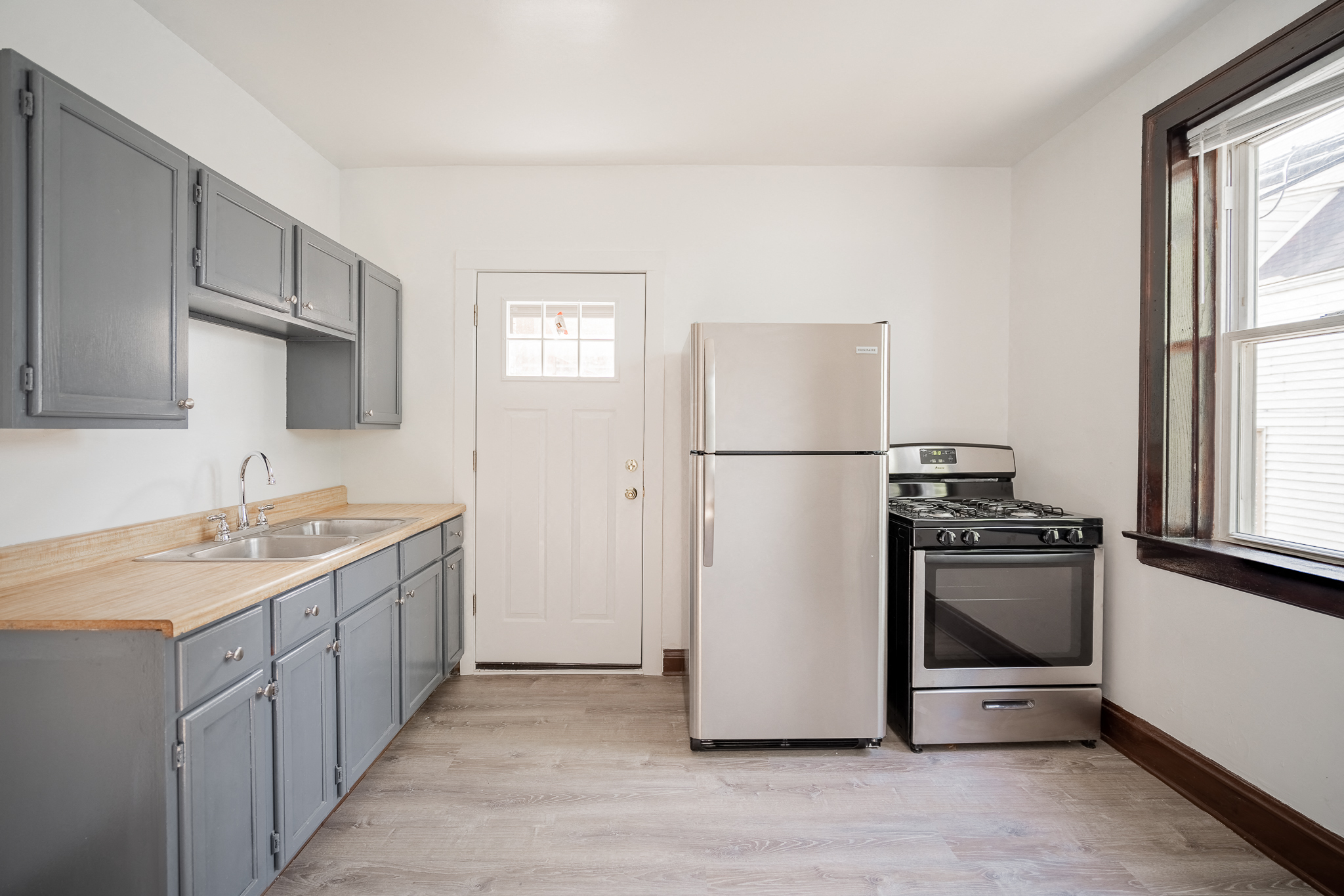 an empty kitchen with stainless steel appliances and blue cabinets
