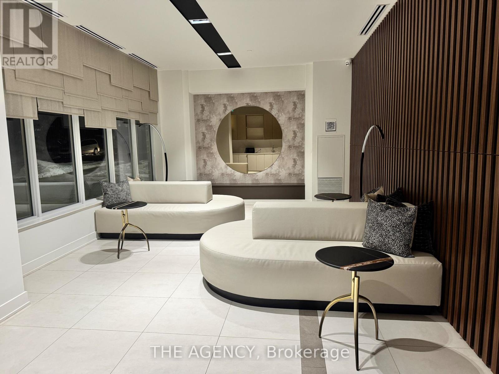 A modern living room with a white sofa and a round black table.