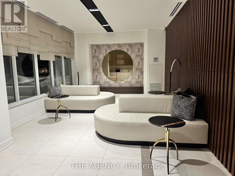 A modern living room with a white sofa and a round black table.