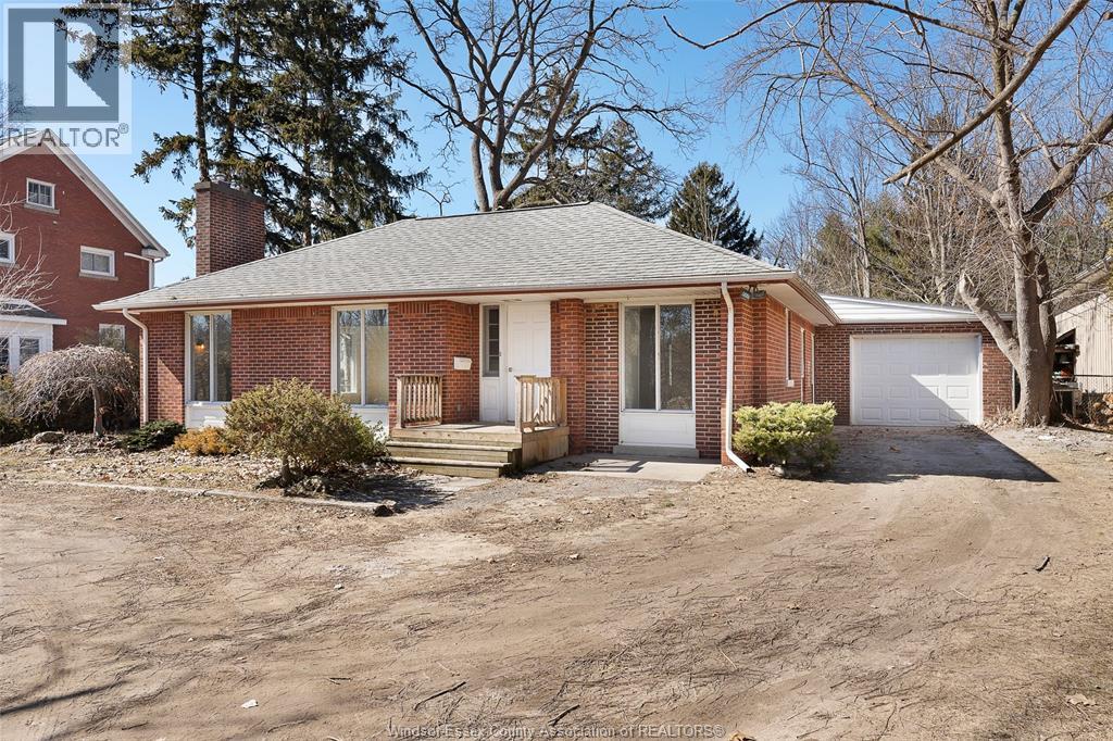 A house with a brick exterior and a white garage door is for sale.
