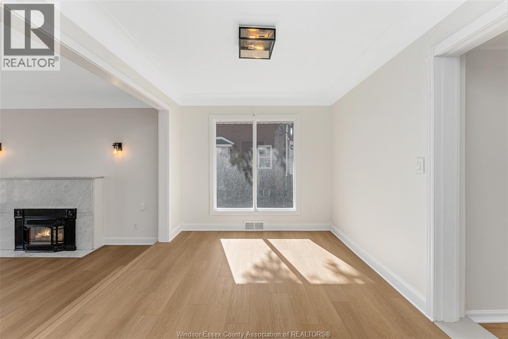 A spacious room with a fireplace and a large window.