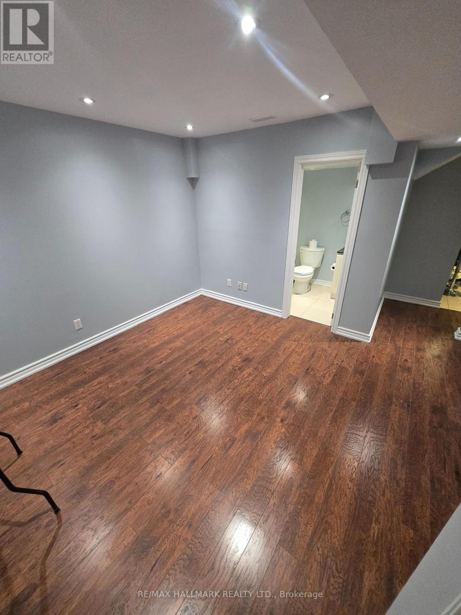 A room with wooden flooring and a grey wall.