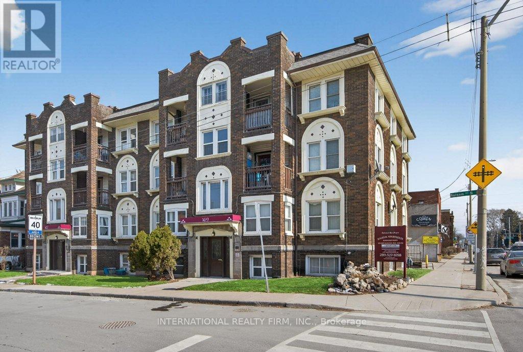 A street view of a multi-story building with a sign for International Realty Firm, INC. on the bottom.
