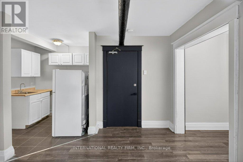 A kitchen with white cabinets and a black door.