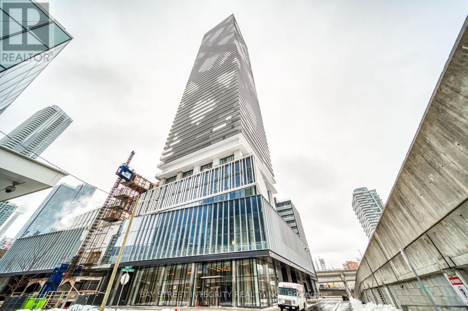 A tall building under construction with a crane in the foreground.