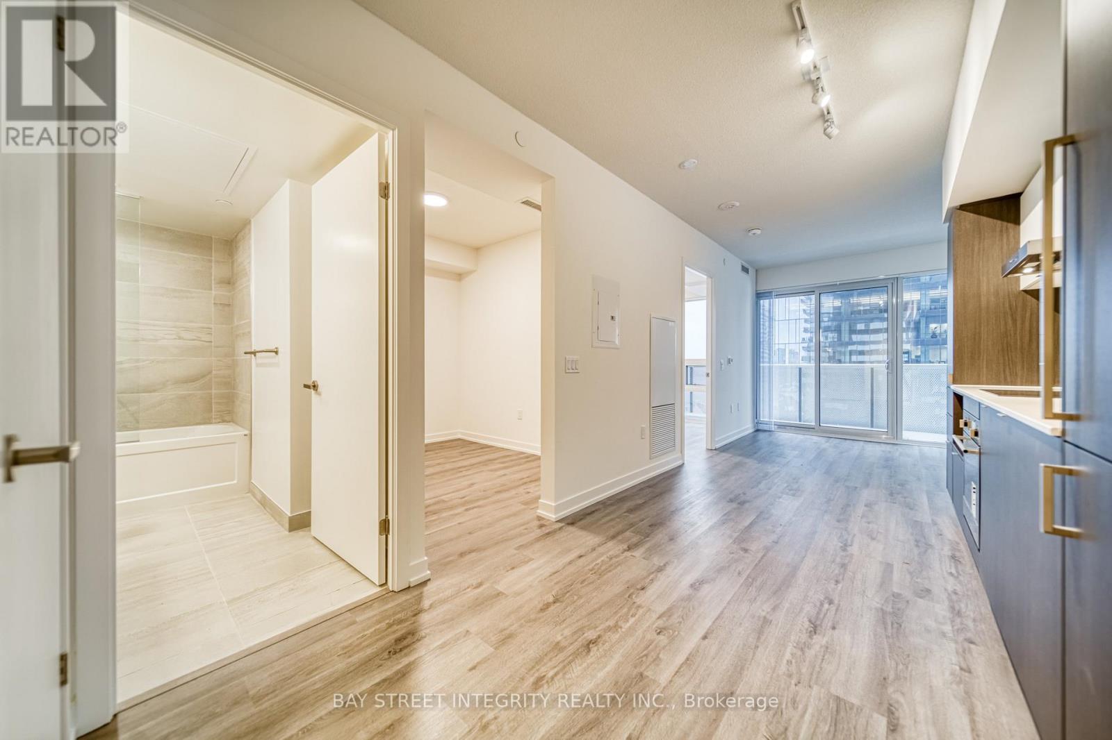 A spacious room with wooden flooring and white walls.