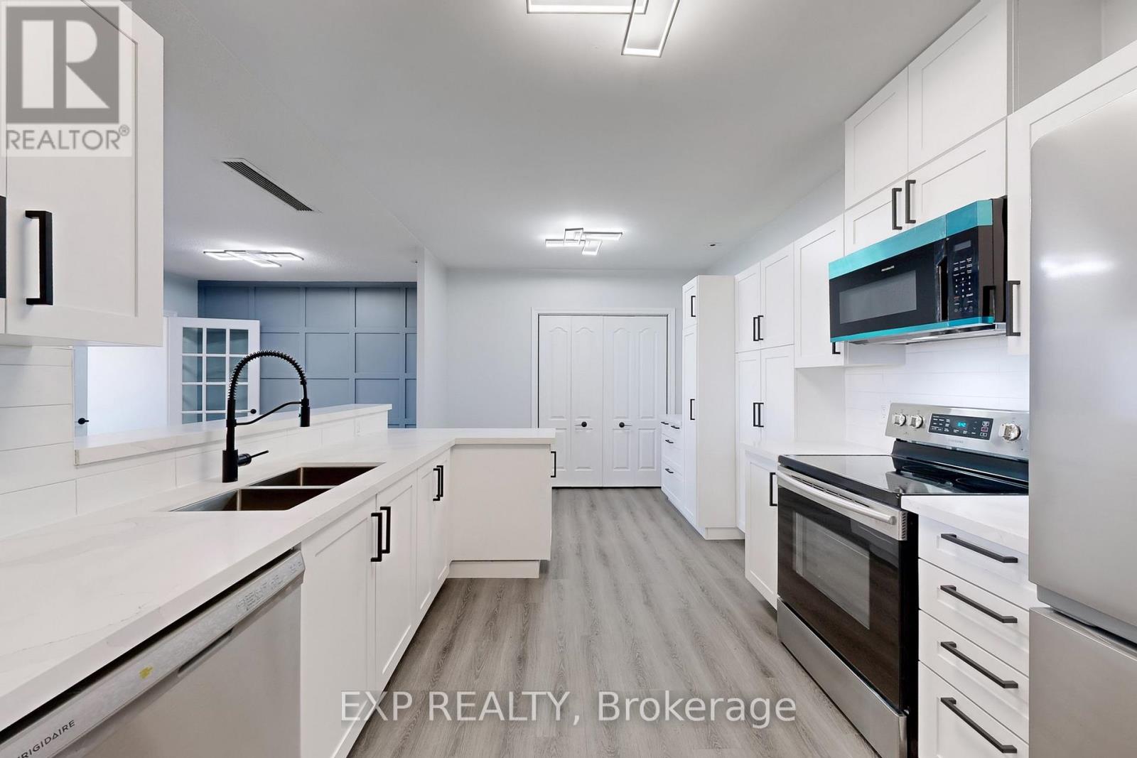 A modern kitchen with white cabinets and appliances.