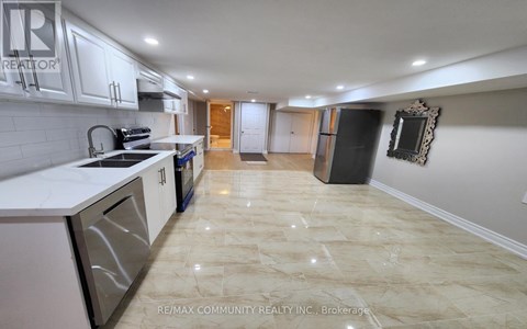 A kitchen with white cabinets and a marble floor.