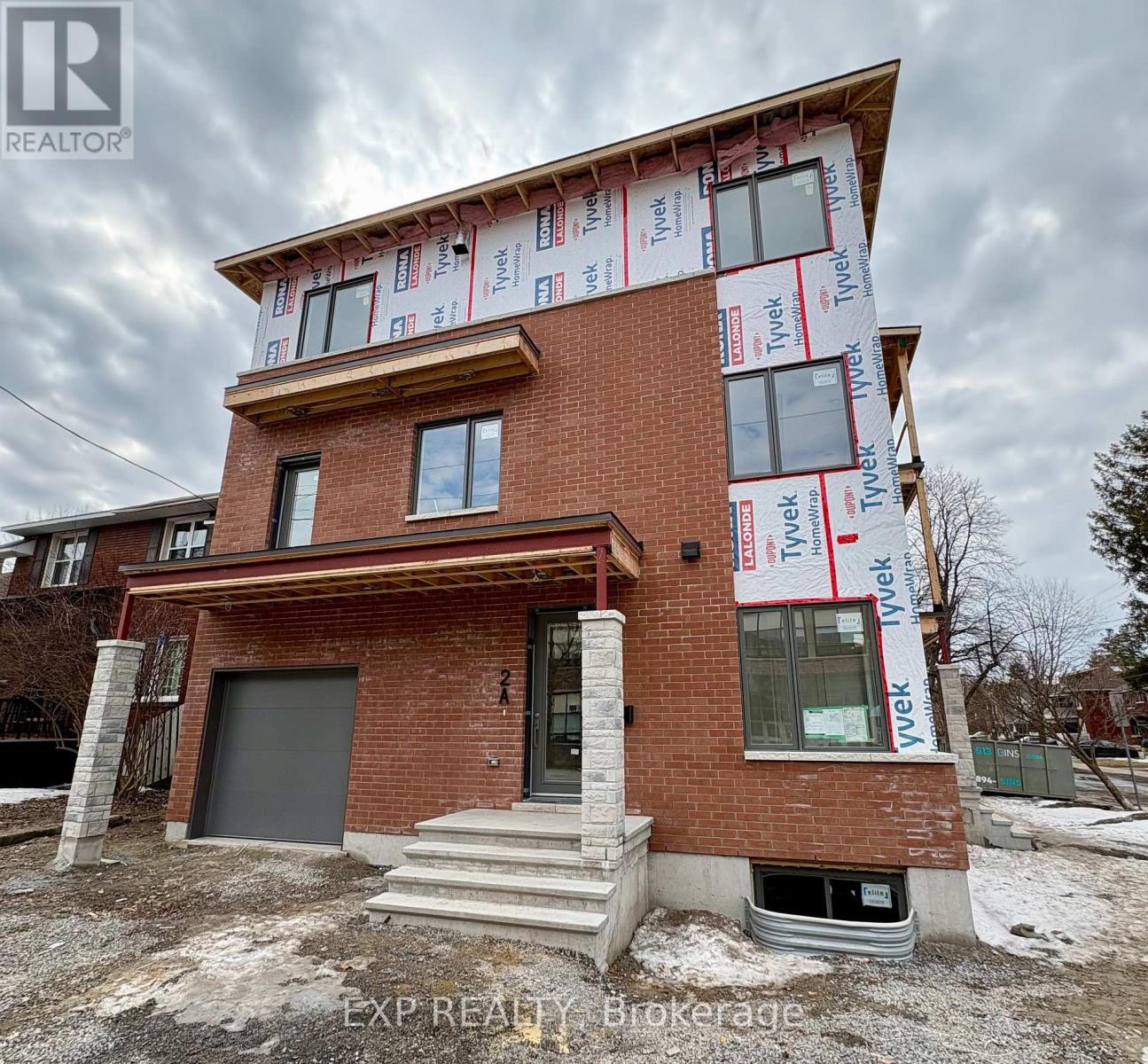 A house under construction with the words EXP REALTY Brokerage visible.