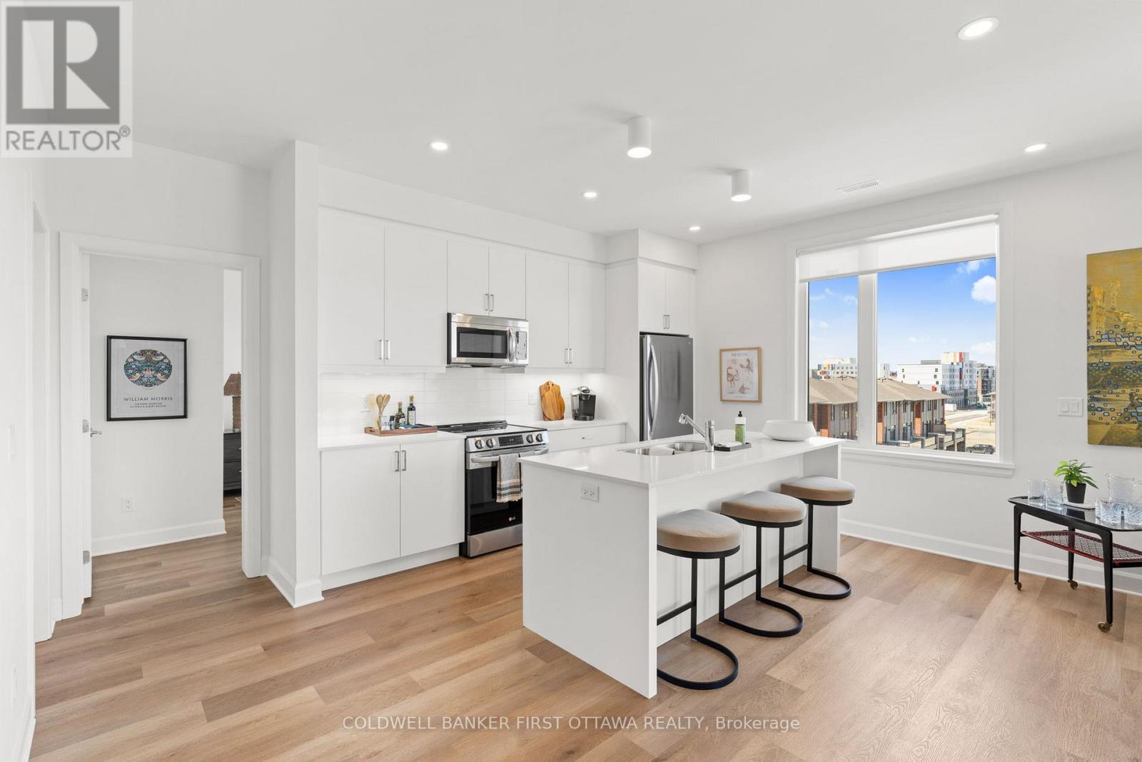A modern kitchen with white cabinets and a bar area.