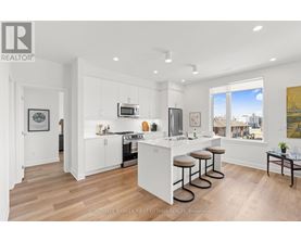 A modern kitchen with white cabinets and a bar area.