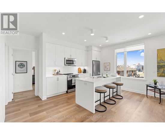 A modern kitchen with white cabinets and a bar area.