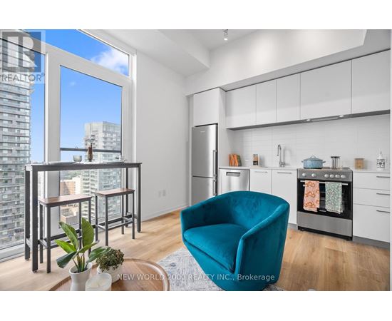A modern kitchen with a teal chair and a view of the city.