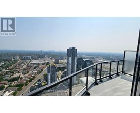 A balcony overlooks a cityscape with a highway and buildings.