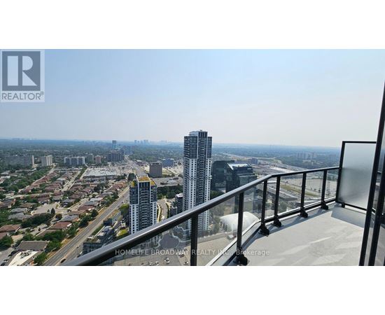 A balcony overlooks a cityscape with a highway and buildings.