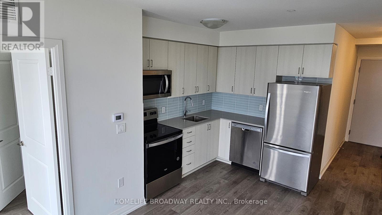 A kitchen with white cabinets and stainless steel appliances.