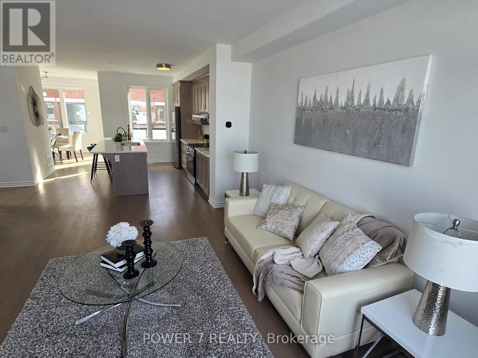 A living room with a grey coffee table and a grey sofa with a white cushion.
