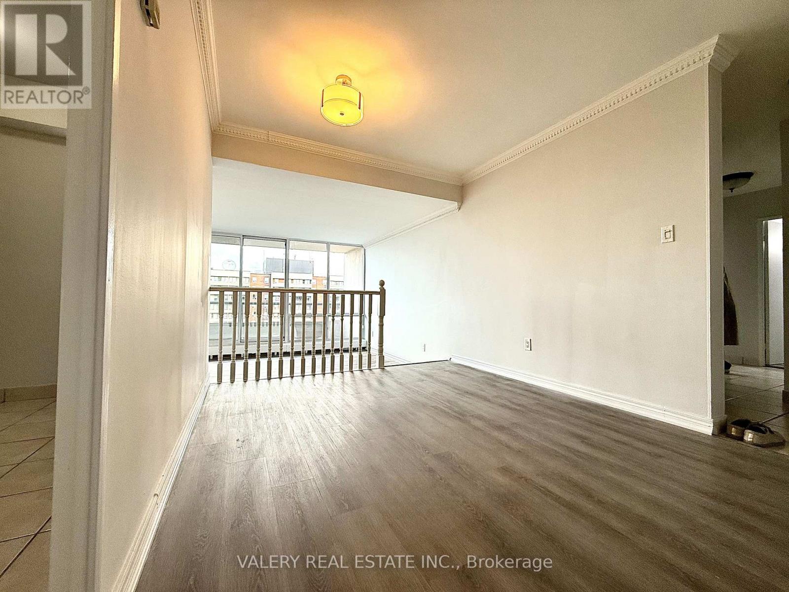 A room with a window and a wooden floor.