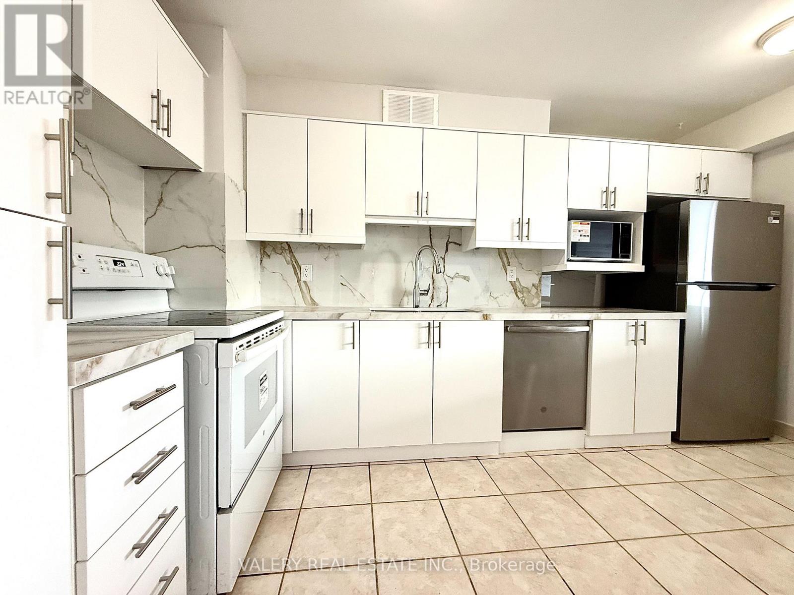 A kitchen with white cabinets and appliances.
