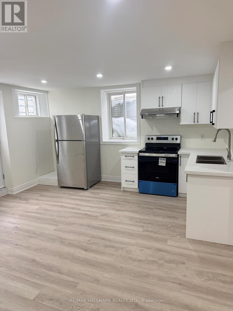 A kitchen with a refrigerator, stove, and sink.