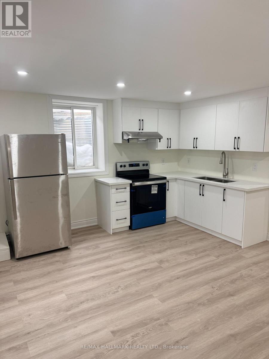 A kitchen with white cabinets and a stainless steel refrigerator.