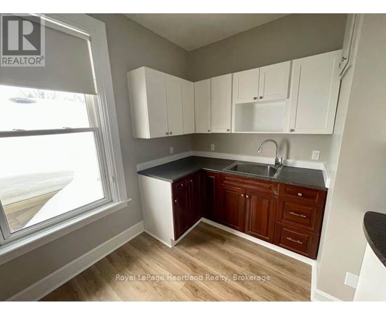 A kitchen with white cabinets and a black countertop.