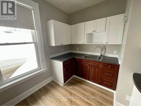 A kitchen with white cabinets and a black countertop.