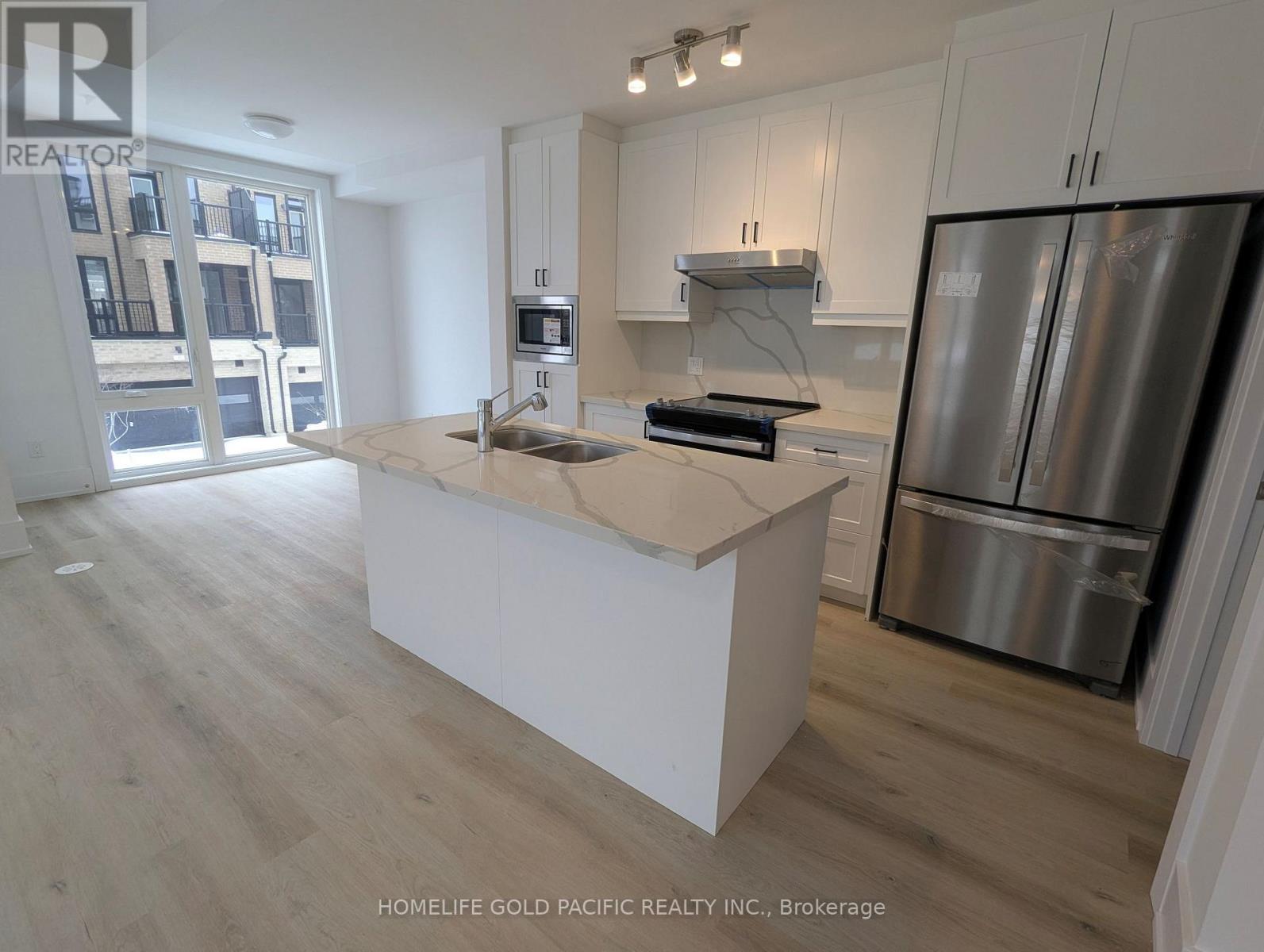 A kitchen with white cabinets and a wooden island.