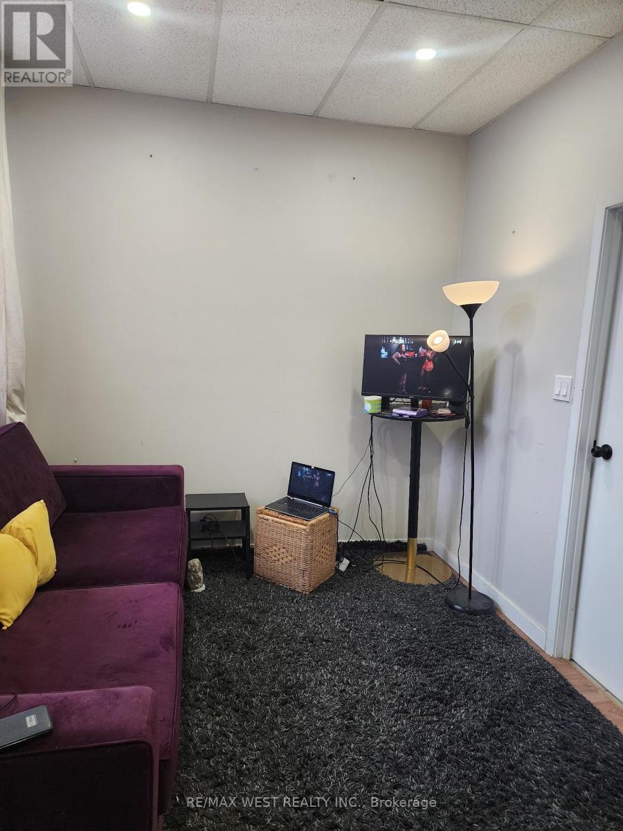 A purple couch sits in a living room with a television on a stand.
