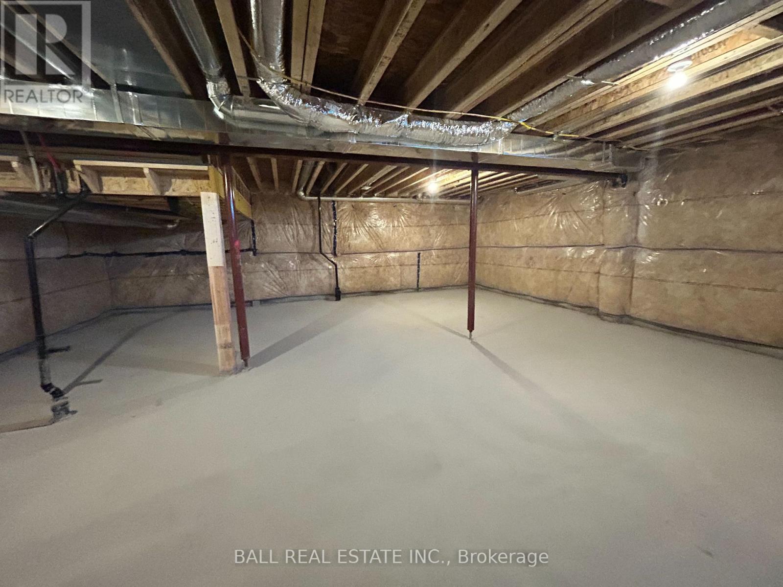 A spacious basement with a concrete floor and walls covered in insulation.