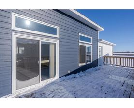 A house with a grey siding and a white door and windows.