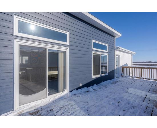 A house with a grey siding and a white door and windows.
