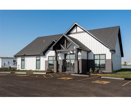 A modern building with a parking lot in front.