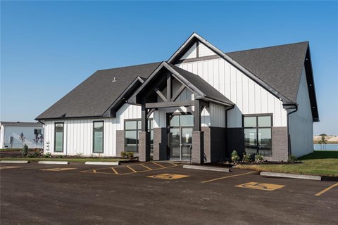A modern building with a parking lot in front.
