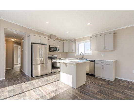 A kitchen with a refrigerator, microwave, and oven.