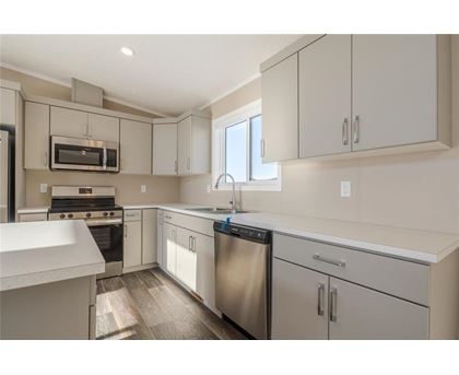 A kitchen with white cabinets and stainless steel appliances.