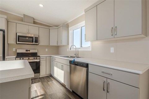 A kitchen with white cabinets and stainless steel appliances.