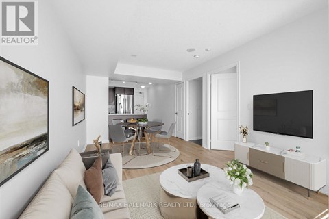A modern living room with a large painting on the wall and a flat screen TV mounted above the entertainment unit.