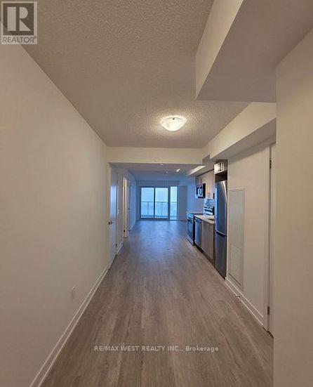 A long hallway with a kitchen area at the end.