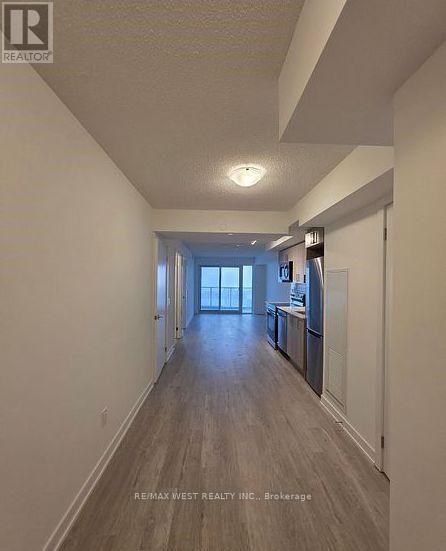 A long hallway with a kitchen area at the end.