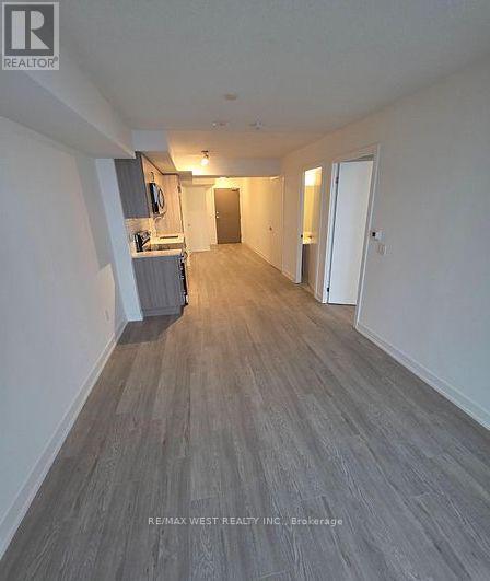 A long hallway with a Re/Max West Realty Inc. sign on the bottom left.