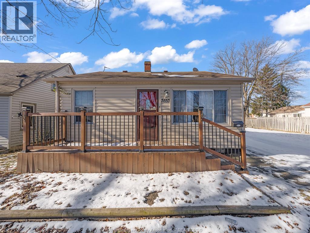 A house with a brown deck in the snow.