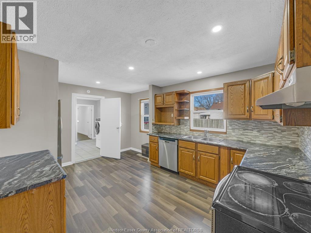 A kitchen with wooden cabinets and a black counter top.