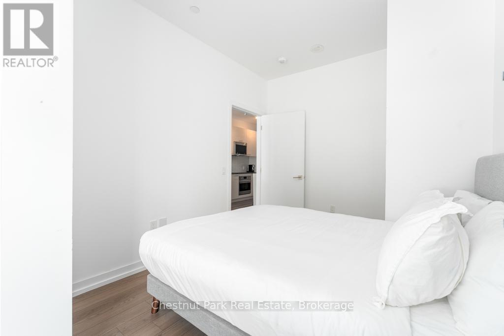 A bedroom with a bed, nightstand and a small closet.