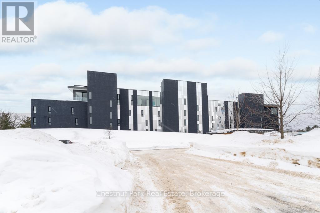 A large, modern building with a flat roof and a dirt road leading up to it.