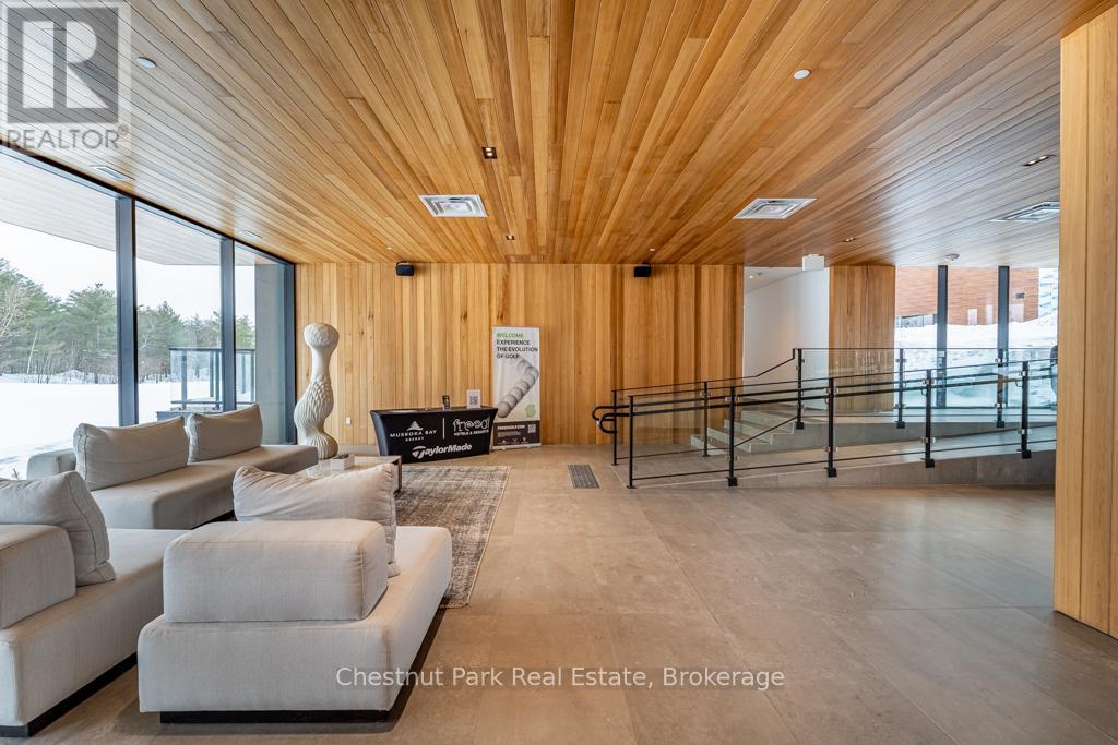 A spacious living room with a wooden ceiling and white furniture.