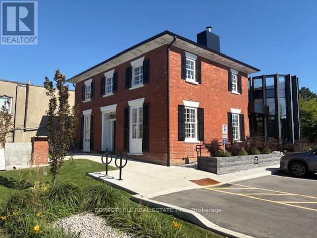 A red brick building with a black roof and white trim.