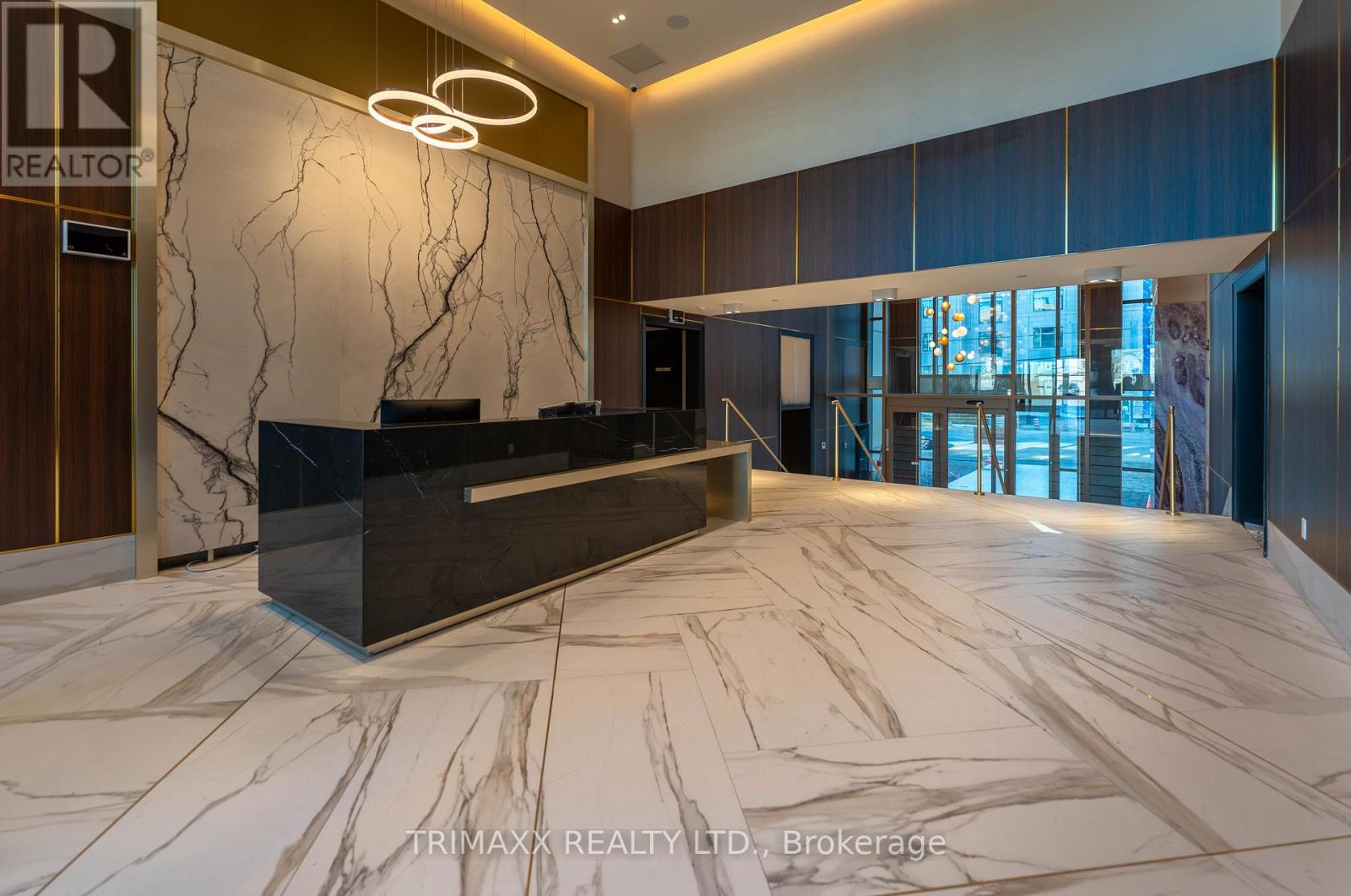 A reception area with a marble floor and a dark wood door.